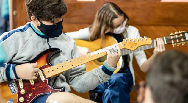 Estudantes do Bernoulli tocando instrumentos musicais. 