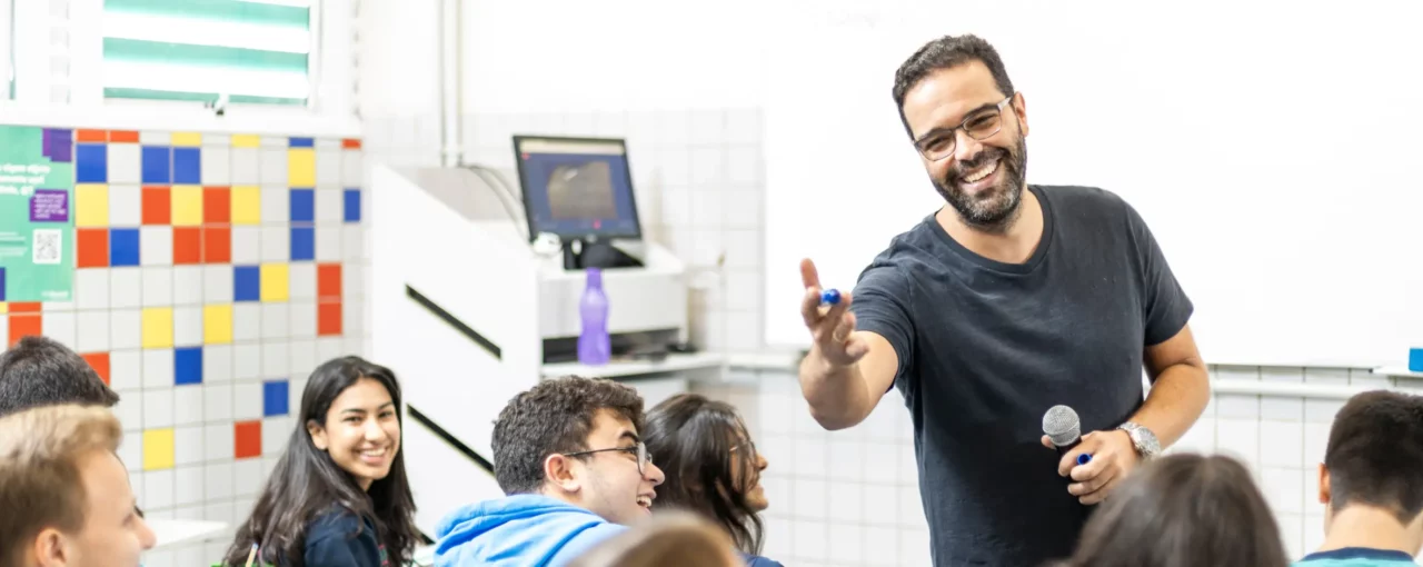 Professor em sala de aula passando a palavra para estudante do Bernoulli