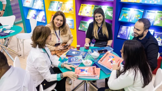 Foto de um grupo de educadores discutindo sobre os livros didáticos do Bernoulli