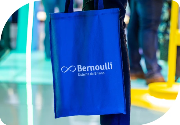 Homem segurando uma sacola com a marca Bernoulli Sistema de Ensino