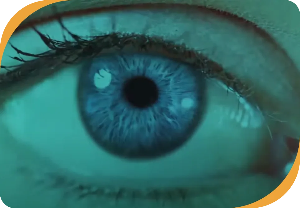 Thumb do vídeo Olho brilha mostrando a foto do olho direito de uma pessoa em destaque sob filtro esverdeado.