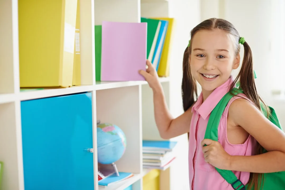  Criança se preparando para a volta às aulas com livros e material escolar