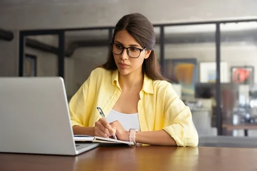 Jovem concentrada conferindo no computador