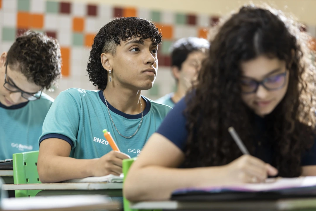 Alunos em sala de aula durante atividade escolar, representando diferenças entre ensino tradicional e construtivista 