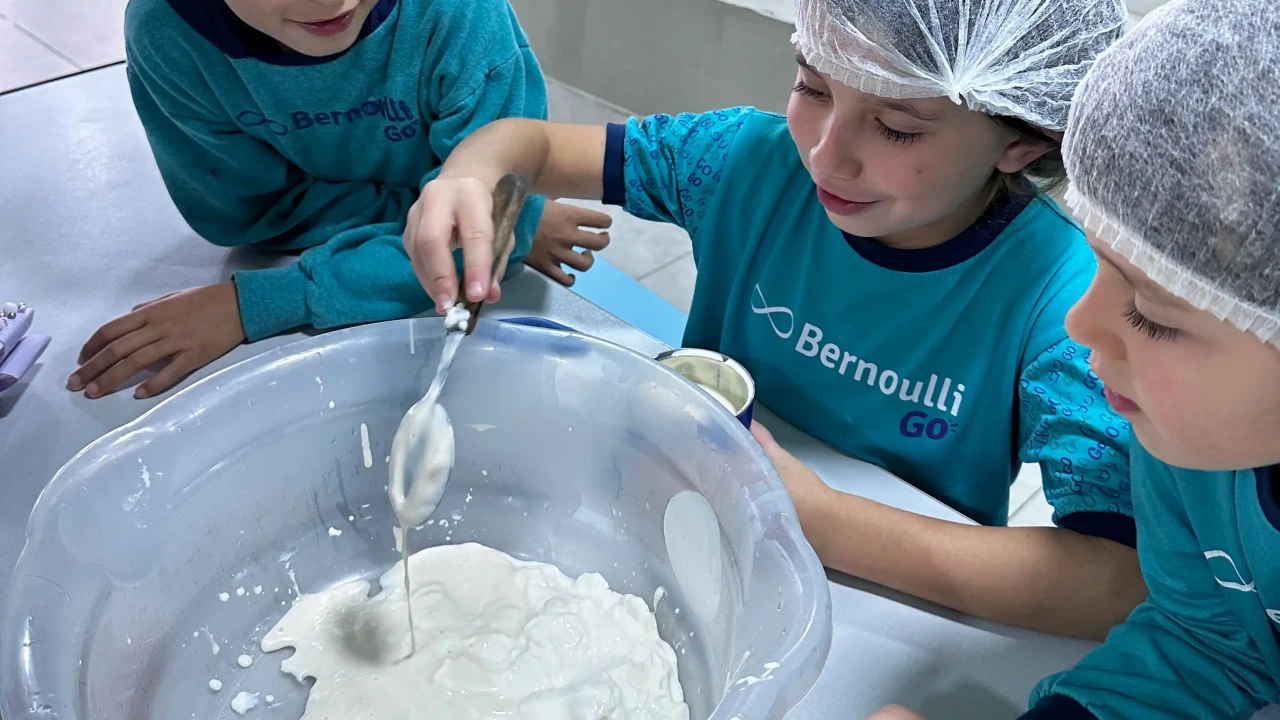 Estudantes misturando ingredientes durante uma aula de cozinha pedagógica, demonstrando a importância da curiosidade para o desenvolvimento intelectual